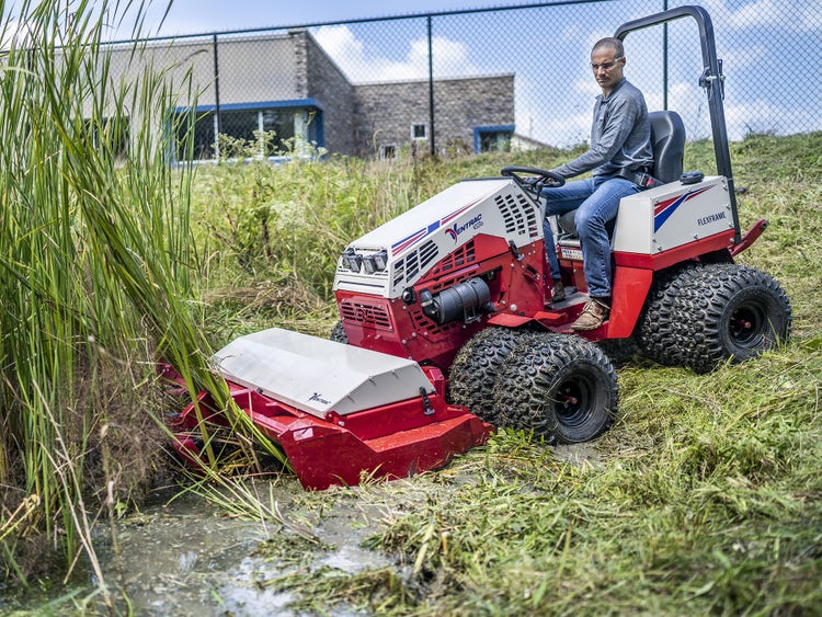 Mann fährt auf Ventrak Mäher in sumpfigen Schilf