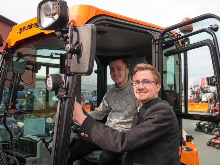 2 Verkäufer stehen bei beinem Multihog Fahrzeug und erklären das Fahrzeug