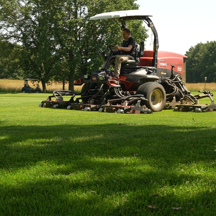 Ein Toro-Mährtraktor fährt über einen gut gepflegten Golfplatz
