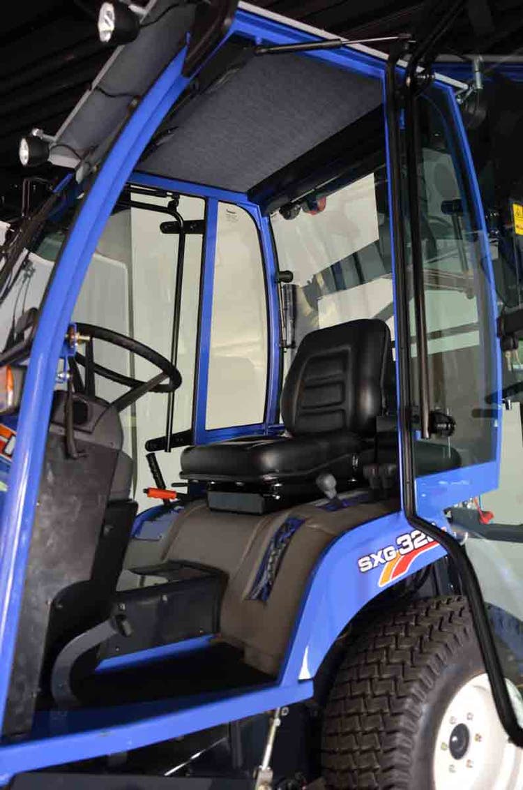 Iseki SXG 3+ mit Kabine steht in einer Garage