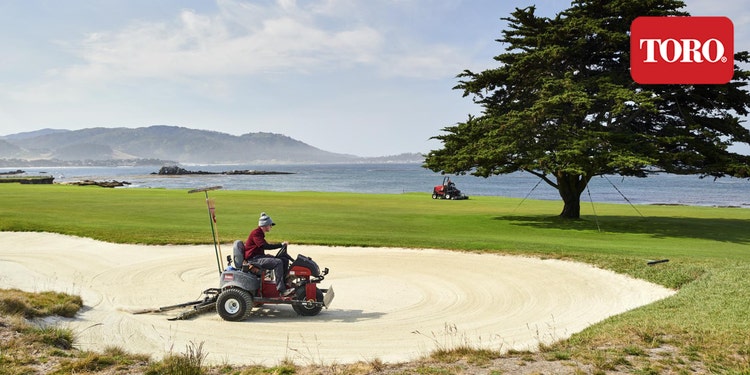Mann pflegt Bunker mit Toro SandPro 3040 auf Golfplatz