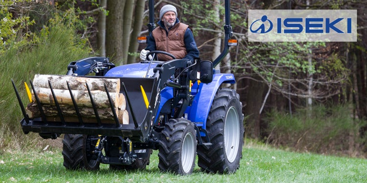 Mann fährt auf Iseki und transportiert Meterholz mit Laderschaufel