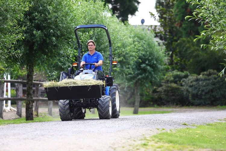 Iseki TM 3187 A / AL Traktor transprotiert Heu in Schaufel
