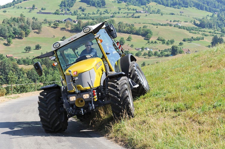 Rigitrac SKH 75/150 Traktor fährt von Wiese auf Straße