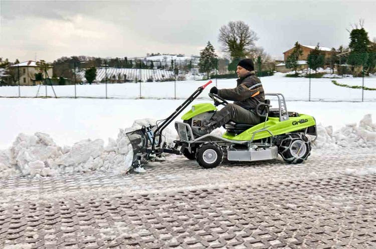Mann räumt Schnee mit Grillo Hochgrasmäher Climber 7.18 und Schneeschild