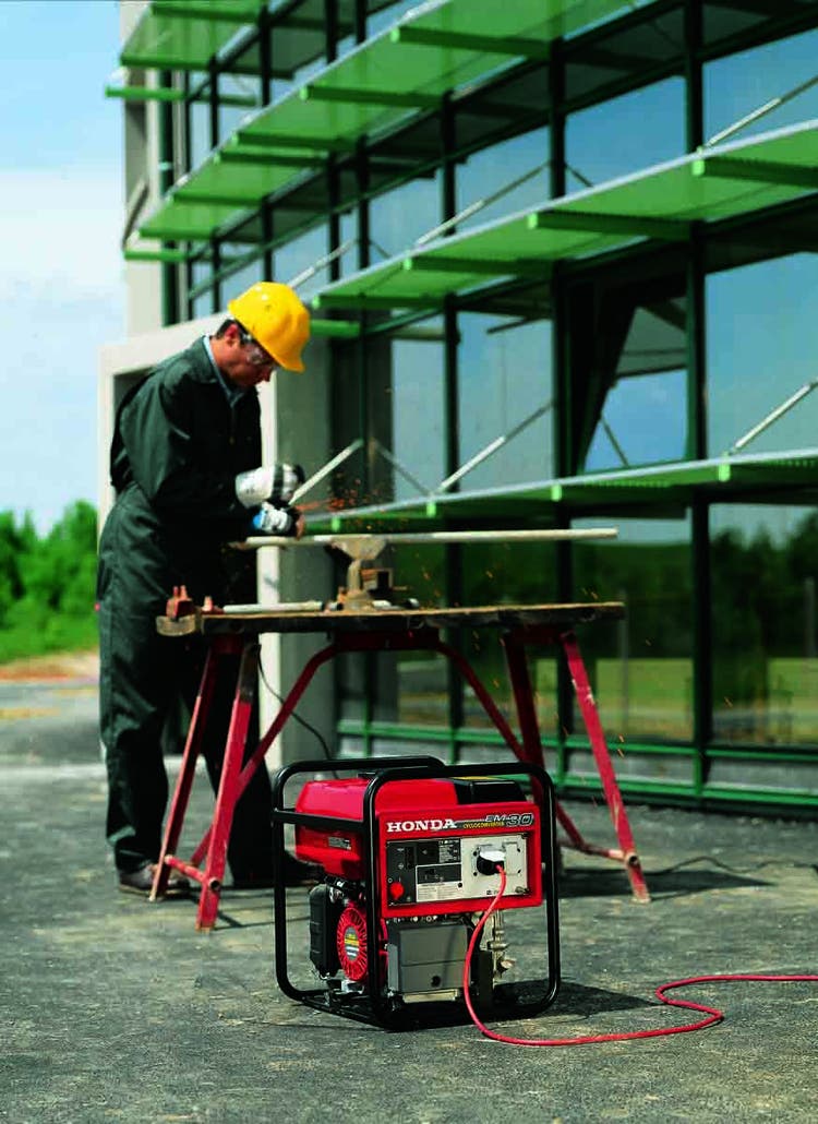 Mann mit Kreissäge beim Arbeiten und Honda EM 30 Stromerzeuger