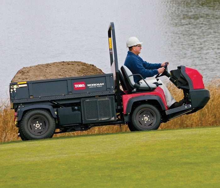 Mann transportiert Sand mit Toro Workman HDX / HDX-4WD