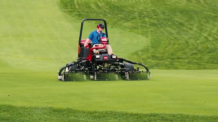 Ein Mann mäht mit dem Toro Reelmaster 3575-D eine große Wiese, die sich über das ganze Bild erstreckt