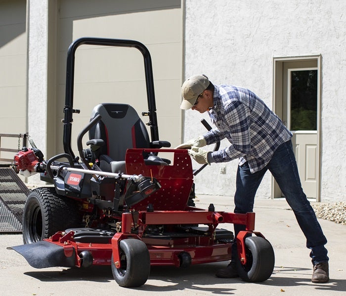 Mann steht an Toro Z-Master 2000 Benzin